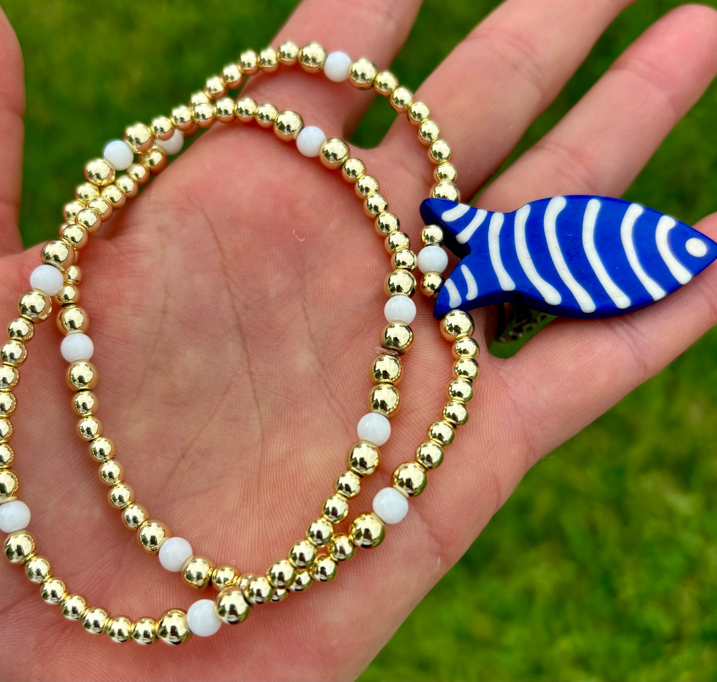 Golden Blue Fish Charm Necklace. 14K Gold Beads & White Glass accents.