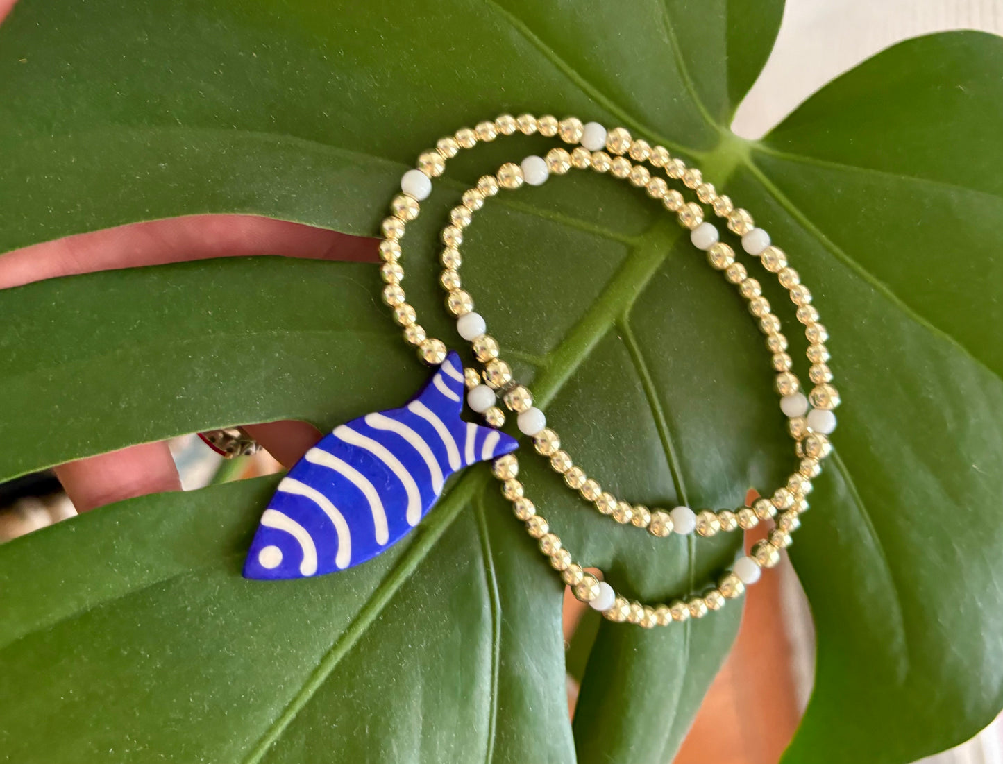 Golden Blue Fish Charm Necklace. 14K Gold Beads & White Glass accents.